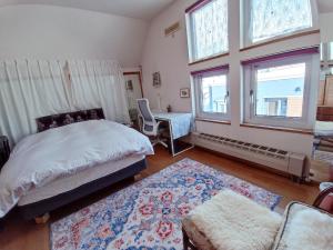 a bedroom with a bed and a desk and windows at Sapporoの実家 B&B Yoshida in Sapporo