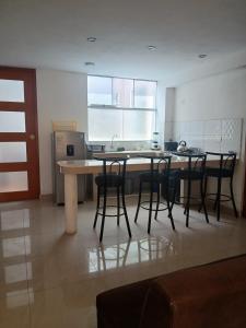 a kitchen with a table and some chairs in it at Apartment, with kitchen, garage and laundry in Tacna