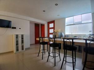 a kitchen with bar stools and a counter in a room at Apartment, with kitchen, garage and laundry in Tacna
