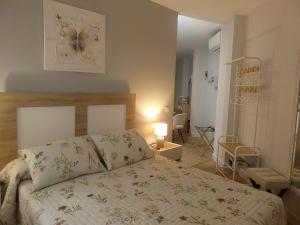 a bedroom with a bed with a flowery bedspread and a room at Apartamento Fama in Cáceres
