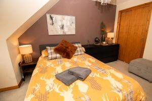 a bedroom with a bed with a yellow comforter at Inverness Holiday House - 2 Bedroom in Inverness