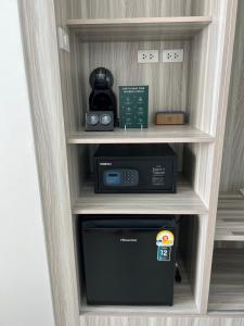 a microwave in a book shelf in a room at ThreeTreesSamuiPoolVilla in Ban Thung