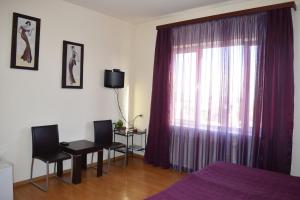 a bedroom with a bed and a window with purple curtains at Hotel Grig in Yerevan