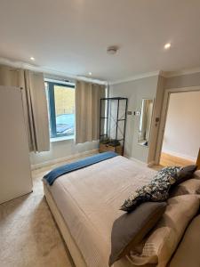 ein Schlafzimmer mit großem Bett und Fenster in der Unterkunft Cozy Flat with garden in Prime Location in Brentford