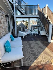 a white couch on a deck with a staircase at Mercury Hotel Provincetown in Provincetown