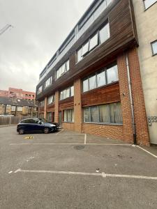ein Auto, das auf einem Parkplatz vor einem Gebäude geparkt ist in der Unterkunft Cozy Flat with garden in Prime Location in Brentford