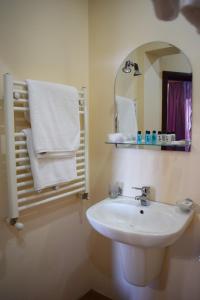 a bathroom with a sink and a mirror and towels at Hotel Grig in Yerevan