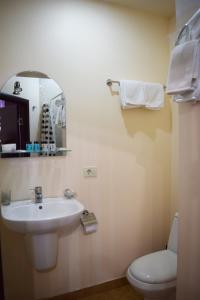 a bathroom with a sink and a toilet and a mirror at Hotel Grig in Yerevan +49 photos