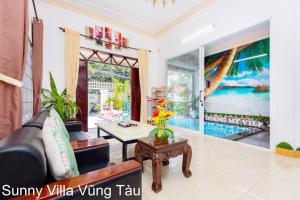 a living room with a couch and a table at Sunny Villa 109 Võ Thị Sáu in Vung Tau