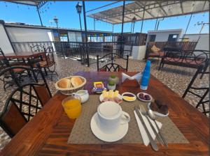 a wooden table with breakfast food on top of a balcony at Hotel Andalucía in Arica