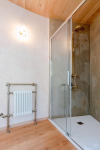 een glazen douche in een kamer met een houten plafond bij Le Silo du Domaine des Ecus d'Or in Veuvey-sur-Ouche