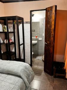 a bedroom with a bed and a bathroom with a shower at El Refugio in Yala