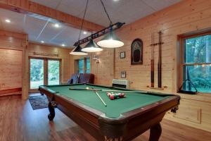 a pool table in a room with wooden walls at Astounding River View - Outdoor Hot Tub, Volleyball Net, Game Room + More! in Copperhill
