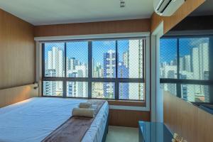 a bedroom with a bed and a large window at Allure Residence by Carpediem in Recife +145 photos