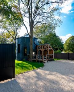 een rond huis met een boom en een hek bij Le Silo du Domaine des Ecus d'Or in Veuvey-sur-Ouche