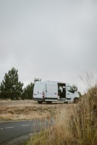 una furgoneta blanca estacionada al lado de una carretera en Bawhee - Campervan, en Caniço