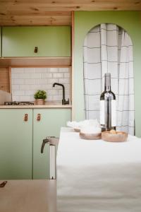 Una cocina con una botella de vino en la encimera. en Bawhee - Campervan, en Caniço
