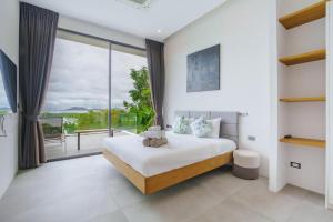 a bedroom with a bed and a large window at Yamu Hills Panoramic Ocean View 6 Bed Luxury Vila in Phuket Town +92 photos