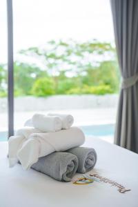 a pile of towels on a table with a window at Yamu Hills Panoramic Ocean View 6 Bed Luxury Vila in Phuket Town