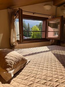 a bedroom with a large bed and a window at Gloria Holiday Home Bormio N10 in Bormio