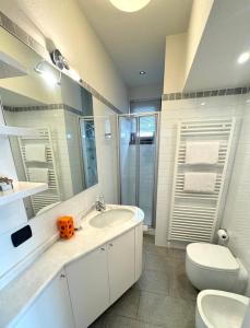 a white bathroom with a toilet and a sink at Gloria Holiday Home Bormio N10 in Bormio