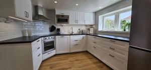 a white kitchen with white cabinets and a window at Apartment in Skärhamn within walking distance to the beach in Toftenäs