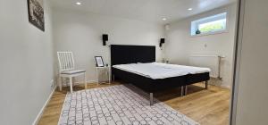 a bedroom with a bed and a window and a chair at Apartment in Skärhamn within walking distance to the beach in Toftenäs