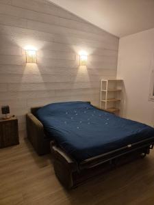a bedroom with a bed with two lights on the wall at Maisonnette près de la plage in Aytré
