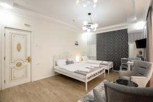 een slaapkamer met een bed, een bank en een stoel bij Hotel Harmony Premium in Koetaisi