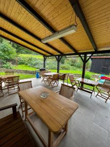 eine Terrasse mit Tischen und Stühlen sowie einem Holztisch in der Unterkunft Penzion U Cempu in Kunratice