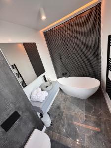 a bathroom with a tub and a toilet and a sink at Sky View Penthouse in Craiova +69 photos