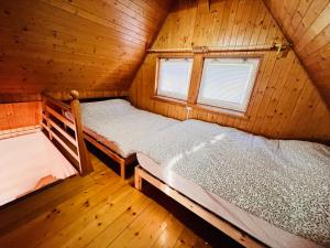 a bedroom with two beds in a wooden cabin at Świerkowa Chata in Targanice