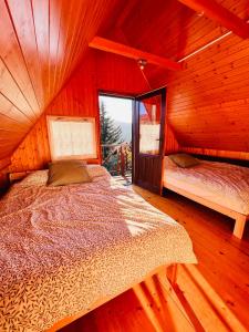 ein Schlafzimmer mit einem Bett in einer Holzhütte in der Unterkunft Świerkowa chata in Targanice