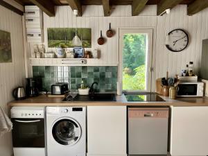 a kitchen with a washing machine and a window at Gîte Du Petit Manoir De La Noue in Cornillé