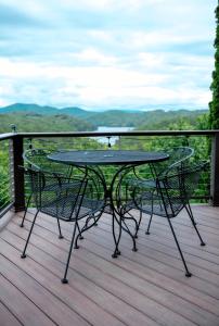 a table and chairs on a deck with a view at Hiwassee Lake Lodge - Private Mtn-Top Retreat - Lake Views - Sleeps 14 in Murphy +51 photos