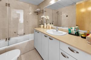 a bathroom with a sink and a toilet and a mirror at Okeanos Sea Loft in Herzliya B