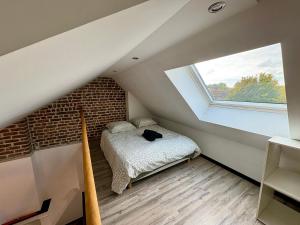 a attic bedroom with a bed and a window at Charmant Duplex 4 pers Au centre Douai Netflix in Douai