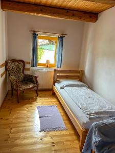 a bedroom with a bed and a chair and a window at Penzion U Cempu in Kunratice