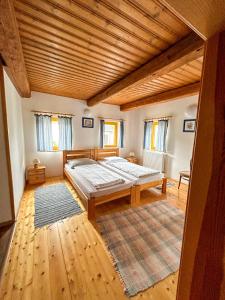 ein Schlafzimmer mit großem Bett und Holzdecke in der Unterkunft Penzion U Cempu in Kunratice
