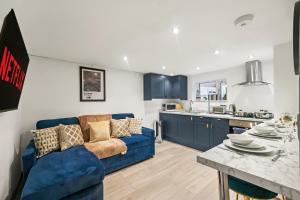 Una sala de estar con un sofá azul y una cocina. en Sleek and Stylish Yorkshire Gem - Sleeps 4, en Castleford 10 fotos más