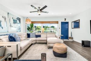 a living room with a couch and a ceiling fan at Relaxing Salt Pool & Spa, Walk to Key Lime House! in Lantana