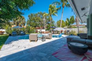 a patio with lounge chairs and a pool at Relaxing Salt Pool & Spa, Walk to Key Lime House! in Lantana