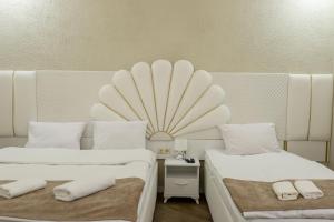 een kamer met 2 bedden en een tafel met een spiegel bij Hotel Harmony Premium in Koetaisi
