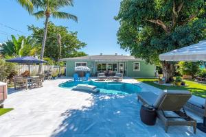 a backyard with a swimming pool and a house at Relaxing Salt Pool & Spa, Walk to Key Lime House! in Lantana