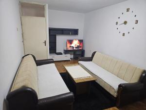 a living room with a couch and a tv at Nina in Kuršumlija