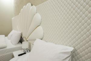 een slaapkamer met 2 bedden met witte lakens en kussens bij Hotel Harmony Premium in Koetaisi