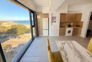 une cuisine avec une table et une vue sur l'océan dans l'établissement Maritimo ApartHotel, à Constanţa