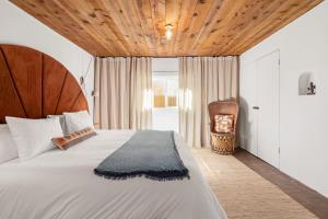 ein Schlafzimmer mit einem großen Bett und einer Holzdecke in der Unterkunft Central Location - Adorable Adobe - King and Queen in Santa Fe