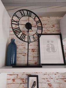 a clock on a shelf with a picture and a vase at Sepa in Chioggia +12 photos