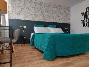 a bed with a green comforter in a bedroom at Sepa in Chioggia